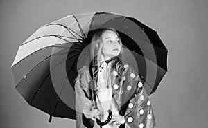 Kid girl happy hold colorful umbrella wear waterproof cloak. Waterproof accessories for children. Enjoy rainy weather