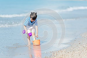 Kid girl have fun and playing sand and water at tropical beach. Family child tourism travel enjoy and freedom in summer and holida