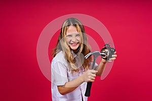 Kid girl holding hammer and alarm clock smiling with a happy and cool smile on face. showing teeth.