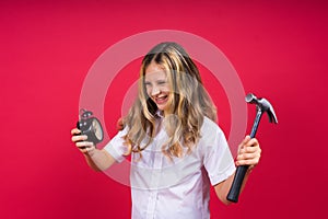 Kid girl holding hammer and alarm clock smiling with a happy and cool smile on face. showing teeth