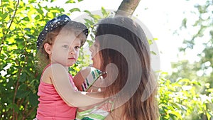 Kid girl kissing joying happy mother outdoors