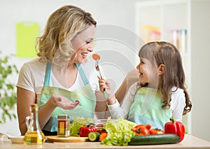 Kid girl and mother eating healthy food vegetables