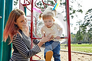 Kid girl and mother playing playground ladder