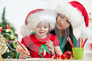 Kid girl and mother writing letter to Santa