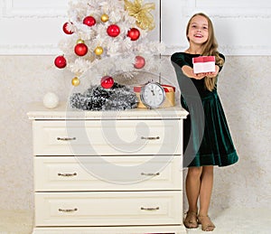 Kid girl near christmas tree hold gift box. Time to open christmas gifts. Merry christmas concept. Dreams come true