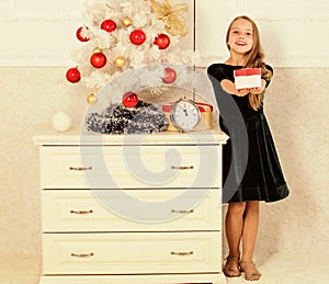 Kid girl near christmas tree hold gift box. Time to open christmas gifts. Merry christmas concept. Dreams come true