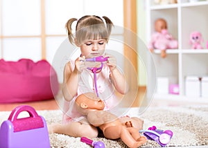 Kid girl playing the doctor with her newborn baby