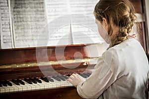 Kid girl playing on piano