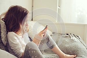 Kid girl playing smartphone at home