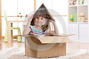 Kid girl playing in a toy house in children room