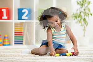 Kid girl playing toys at kindergarten room