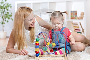 Kid girl plays with educational toy indoor. Happy