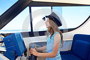 Kid girl pretending be a captain sailor cap in boat