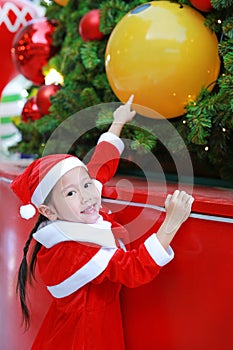 Kid girl in Santa hat having fun at Christmas time. Merry Xmas background