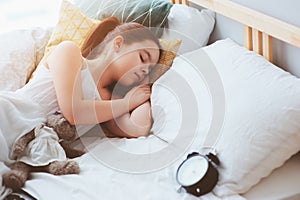 Kid girl sleeping in early morning in bed