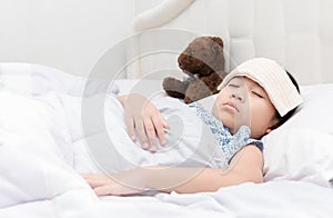 Kid girl sleeping and sick on the bed with cooler handkerchief o