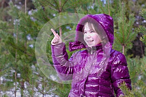 Kid girl surprised pointing finger pine forest