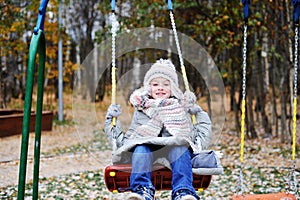 Kid girl on a swing at beautiful winter day