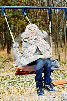 Kid girl on a swing at beautiful winter day