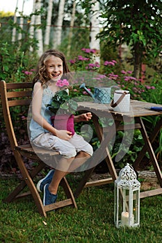 Kid girl walking with candle holder in romantic evening garden