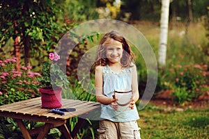 Kid girl walking with candle holder in romantic evening garden