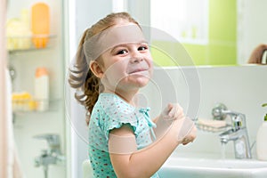 Kid girl washing his face and hands