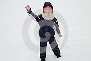 Kid girl in winter clothes plying in deep snow photo