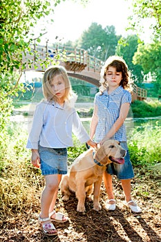 Kid girls with Golden retriever puppy outdoor