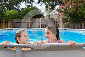 Kid girls swimming in the pool in backyard