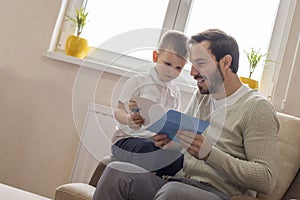 Kid giving a greeting  card to his father