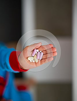 Kid hand holding pills and capsule for eat to cure healthcare vi