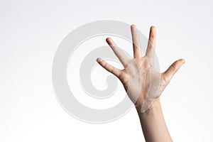 Kid hand showing and pointing up with fingers number five on white wall background