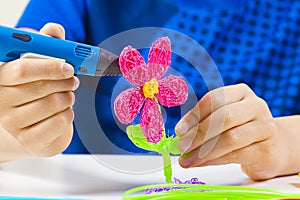 Kid hands creating with blue 3d printing pen