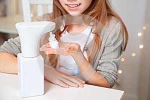 Kid hands disinfect with soap automatic dispenser