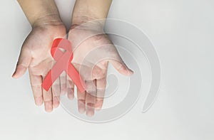 Kid hands holding red AIDS awareness ribbon. Aids Awareness