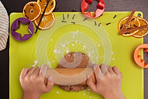 Kid hands stretching the gingerbread cookies dough