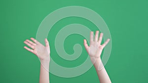 Kid hands waving saying greeting, goodbye making hand gestures on chroma key green screen background