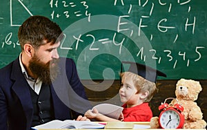 Kid happy studies individually with teacher, at home. Individual schooling concept. Father with beard, teacher teaches