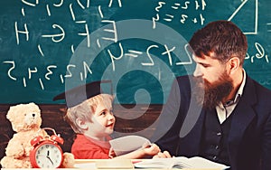 Kid happy studies individually with teacher, at home. Individual schooling concept. Father with beard, teacher teaches