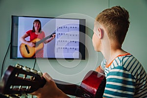 Kid having guitar lesson online, distant learning