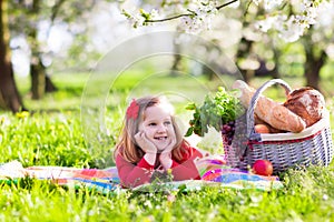 Kid having picnic in blooming garden