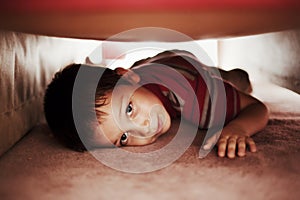 Kid hiding under bed