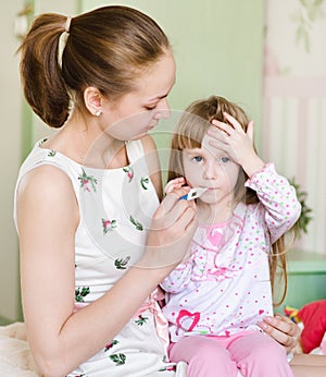 Kid with high fever and mother taking temperature