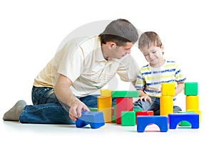 Kid and his dad play toys together