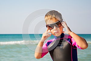 Kid in his diving suit and glasses at the beach