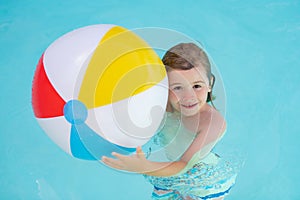 Kid hold rubber air ball in pool. Happy child having fun on summer vacation. Kid playing with ball in the swimming pool