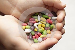 Kid holding candy sweet background. Colorful sunflower seeds in a sweet glaze close-up on a white background as a texture