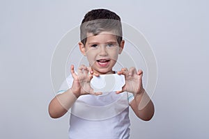 Kid holding discount white card in  hand. Kid with credit card. Little boy showing empty blank paper note copy space.