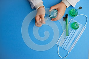 Kid holding flask and glass tube at laboratory, closeup. Solution chemistry. Antivirus solution. Blue and green liquid