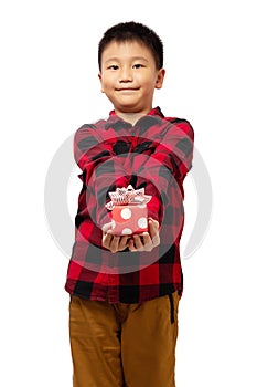 Kid holding and giving christmas gift box with smile wearing red shirt